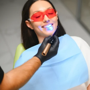 Patient receiving teeth whitening in Newark with protective eyewear during treatment